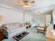 Cozy bedroom with large mirrored wall, ceiling fan, and comfortable seating arrangement at 13227 Molitor Ct, Hudson, FL 34669