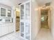 Bright kitchen flows into the hallway featuring modern white cabinetry and appliances, enhancing the home's open layout at 13227 Molitor Ct, Hudson, FL 34669