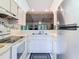 Bright kitchen features stainless steel refrigerator, sleek white appliances and cabinetry, offering a clean design at 13227 Molitor Ct, Hudson, FL 34669