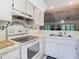 Functional kitchen featuring white appliances, open layout to living area, and decorative accents for a cozy feel at 13227 Molitor Ct, Hudson, FL 34669