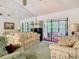 Inviting living room with sliding doors to a sunroom and mirrored wall, perfect for relaxing and entertaining guests at 13227 Molitor Ct, Hudson, FL 34669