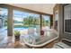 View of the screened-in lanai with outdoor table and chairs overlooking the pool and serene lake at 1528 Jutland Dr, Trinity, FL 34655