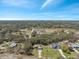 Expansive aerial view of a suburban neighborhood featuring mature trees, a pond, and various single-Gathering homes at 18251 East Rd, Hudson, FL 34667
