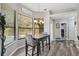 Dining area with view of the backyard, wood-look floors, and a modern light fixture at 18251 East Rd, Hudson, FL 34667
