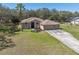 Home with a well-manicured lawn and a circular driveway at 18251 East Rd, Hudson, FL 34667