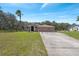 Charming home with a well-maintained lawn, long driveway, and a two-car garage at 18251 East Rd, Hudson, FL 34667