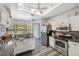 Bright eat-in kitchen with stainless appliances, granite counters, ceiling fan, and modern white cabinets at 18251 East Rd, Hudson, FL 34667