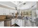 Kitchen with stainless dishwasher, grey wood-look flooring, and white cabinets at 18251 East Rd, Hudson, FL 34667