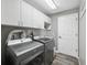 Bright laundry room with modern washer and dryer, cabinets and durable floors at 18251 East Rd, Hudson, FL 34667
