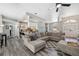 Open-concept living space with modern gray floors, a large sectional sofa, and seamless flow to the kitchen at 18251 East Rd, Hudson, FL 34667