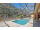 Enjoy the private screened pool with a beautiful view of the surrounding foliage at 18251 East Rd, Hudson, FL 34667