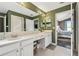 Bathroom featuring double sinks with white cabinets and a doorway to the main bedroom at 215 Arbor Woods Cir, Oldsmar, FL 34677