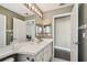 Bathroom featuring a shower stall and vanity area with white cabinetry and framed mirrors at 215 Arbor Woods Cir, Oldsmar, FL 34677