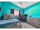 Bedroom featuring light blue walls, ceiling fan, carpeted floors, and an entertainment center at 215 Arbor Woods Cir, Oldsmar, FL 34677
