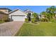 Charming single-Gathering home features a well-manicured lawn, brick driveway, and two-car garage at 215 Arbor Woods Cir, Oldsmar, FL 34677