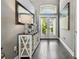 Bright and inviting foyer with transom window, console table, dark wood floors, and a large mirror at 215 Arbor Woods Cir, Oldsmar, FL 34677