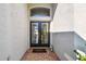 Inviting front entryway with double doors, transom window and 'welcome home' doormat at 215 Arbor Woods Cir, Oldsmar, FL 34677