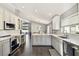 Bright kitchen featuring gray and white cabinets, a kitchen island, and stainless steel appliances at 215 Arbor Woods Cir, Oldsmar, FL 34677