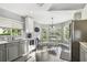 Sunlit kitchen featuring gray cabinetry, stainless steel appliances, and a cozy breakfast area at 215 Arbor Woods Cir, Oldsmar, FL 34677