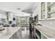 Stylish kitchen with gray cabinets, a breakfast bar with seating, and stainless steel appliances at 215 Arbor Woods Cir, Oldsmar, FL 34677
