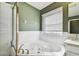 Bathroom featuring a whirlpool tub with decorative fixtures and tiled wall at 215 Arbor Woods Cir, Oldsmar, FL 34677