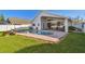 Backyard pool area with brick pavers, green grass, and lounge seating on a sunny day at 215 Arbor Woods Cir, Oldsmar, FL 34677