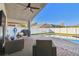 Covered lanai area featuring ceiling fan, wicker chairs, grill and pool with brick pavers at 215 Arbor Woods Cir, Oldsmar, FL 34677