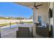 Covered lanai area featuring ceiling fan, wicker chairs, and a pool surrounded by a privacy fence at 215 Arbor Woods Cir, Oldsmar, FL 34677