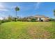 Wide-open backyard with mature landscaping, a screened lanai, and privacy hedges at 2336 Edelweiss Loop, Trinity, FL 34655