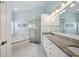 Stylish bathroom boasting dual sinks, granite countertops, a glass-enclosed shower, and a tub at 2336 Edelweiss Loop, Trinity, FL 34655