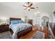 Spacious bedroom showcasing hardwood floors, a ceiling fan, and an ensuite bathroom at 2336 Edelweiss Loop, Trinity, FL 34655