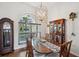 Bright dining room featuring a large window, long table, and decorative chandelier at 2336 Edelweiss Loop, Trinity, FL 34655