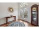 Welcoming foyer with wood floors, rug, statement mirror, and charming grandfather clock at 2336 Edelweiss Loop, Trinity, FL 34655