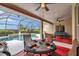 Inviting covered patio featuring a dining table with seating and view of a screened-in pool area at 2336 Edelweiss Loop, Trinity, FL 34655