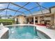 Relaxing pool area with outdoor dining, spillover spa, and a large screened enclosure at 2336 Edelweiss Loop, Trinity, FL 34655