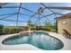 Beautiful screened-in pool with water feature surrounded by lush landscaping at 2336 Edelweiss Loop, Trinity, FL 34655