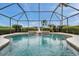 Beautiful screened pool with water feature, lush landscaping, and clear blue skies at 2336 Edelweiss Loop, Trinity, FL 34655