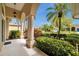 Covered porch with stately columns, manicured hedges and a palm tree in the yard at 2336 Edelweiss Loop, Trinity, FL 34655