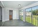 An enclosed balcony area offers green outdoor views, sliding glass doors, and gray flooring at 2464 Australia E Way # 46, Clearwater, FL 33763