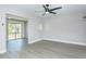 An empty room featuring new gray flooring, a ceiling fan, and sliding glass doors to an outdoor area at 2464 Australia E Way # 46, Clearwater, FL 33763