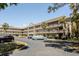An exterior elevation shot of a multi-story building with beige paint and a brown roof with ample parking at 2464 Australia E Way # 46, Clearwater, FL 33763