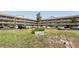 English Tudor condo building featuring well-maintained landscaping, ample parking and an American flag on a sunny day at 2464 Australia E Way # 46, Clearwater, FL 33763