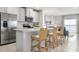 Open kitchen with stainless steel appliances, large island with bar seating overlooking the living area and beautiful lake view at 285 Voltaire Dr, Spring Hill, FL 34609