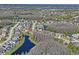 Aerial view of a single-Gathering home with a pool, backyard, pond and located in a wooded residential neighborhood at 3042 Gianna Way, Land O Lakes, FL 34638