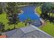 Aerial view of a screened pool overlooking a tranquil pond, surrounded by lush greenery, offering a private oasis at 3042 Gianna Way, Land O Lakes, FL 34638