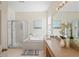 Well-lit bathroom with a soaking tub, a separate shower, and dual sinks at 3042 Gianna Way, Land O Lakes, FL 34638