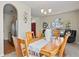 Dining area with wood table set for six, arched doorway, and view to front entry at 3042 Gianna Way, Land O Lakes, FL 34638