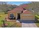 A charming home with a well-kept lawn and a welcoming facade, enhanced by mature landscaping and a two-car garage at 3042 Gianna Way, Land O Lakes, FL 34638