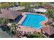 Aerial view of the community pool featuring ample lounge chairs and a covered outdoor dining area at 3042 Gianna Way, Land O Lakes, FL 34638