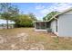 Expansive backyard with mature trees and an enclosed porch offers space for recreation and relaxation at 3209 Kismet Ct, New Port Richey, FL 34655